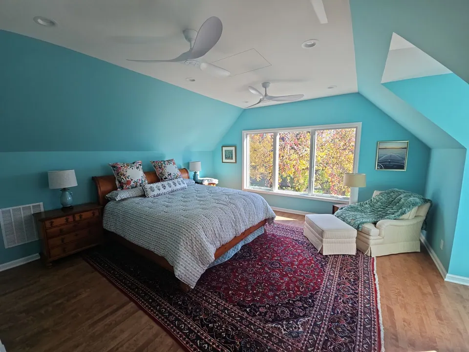 Teal accent wall in a bedroom with a vaulted ceiling
