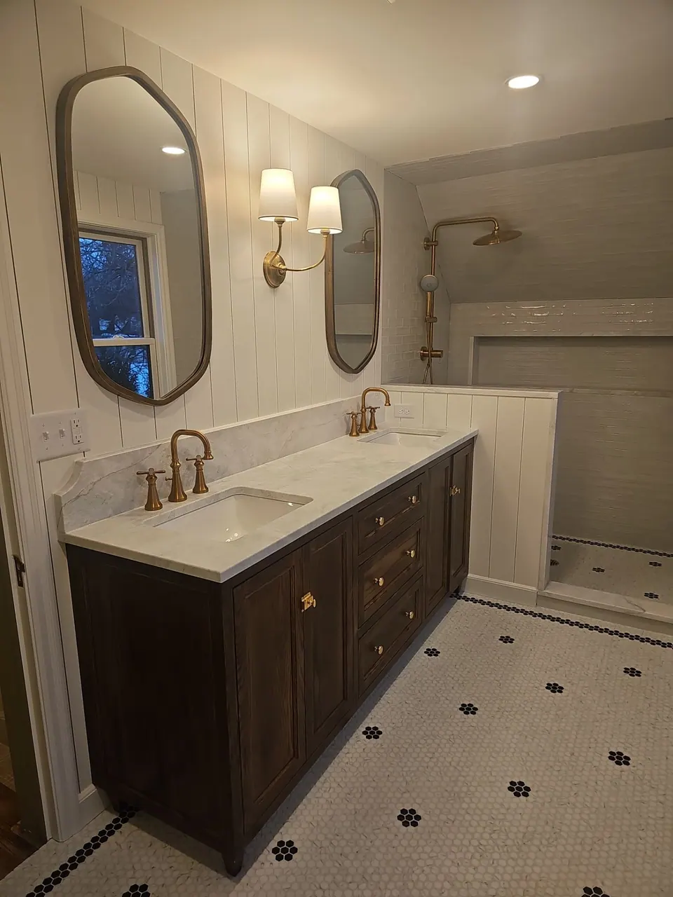 Bathroom with a dark vanity, arched mirror and freshly painted walls