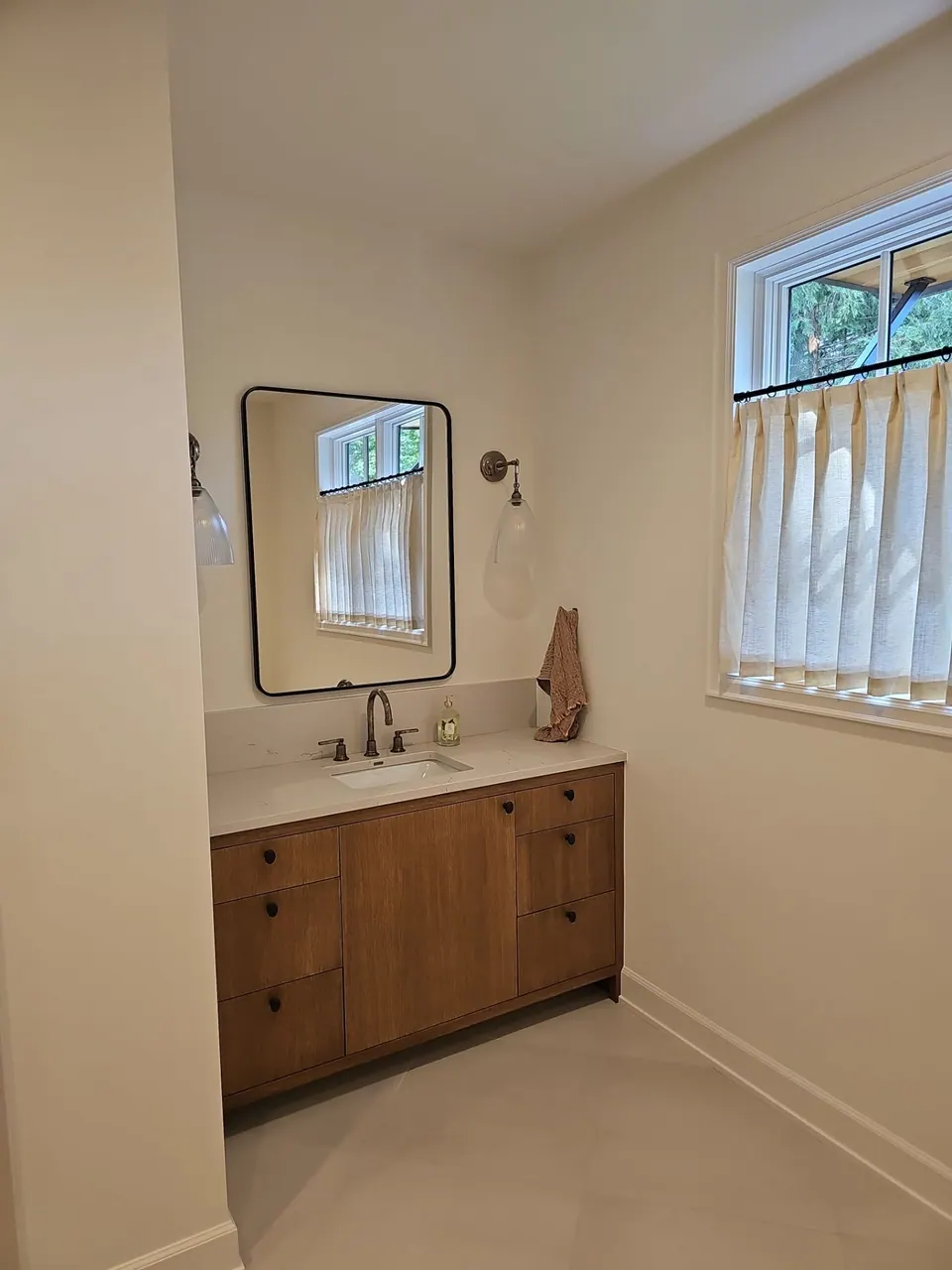 Bathroom with wood vanity and white walls