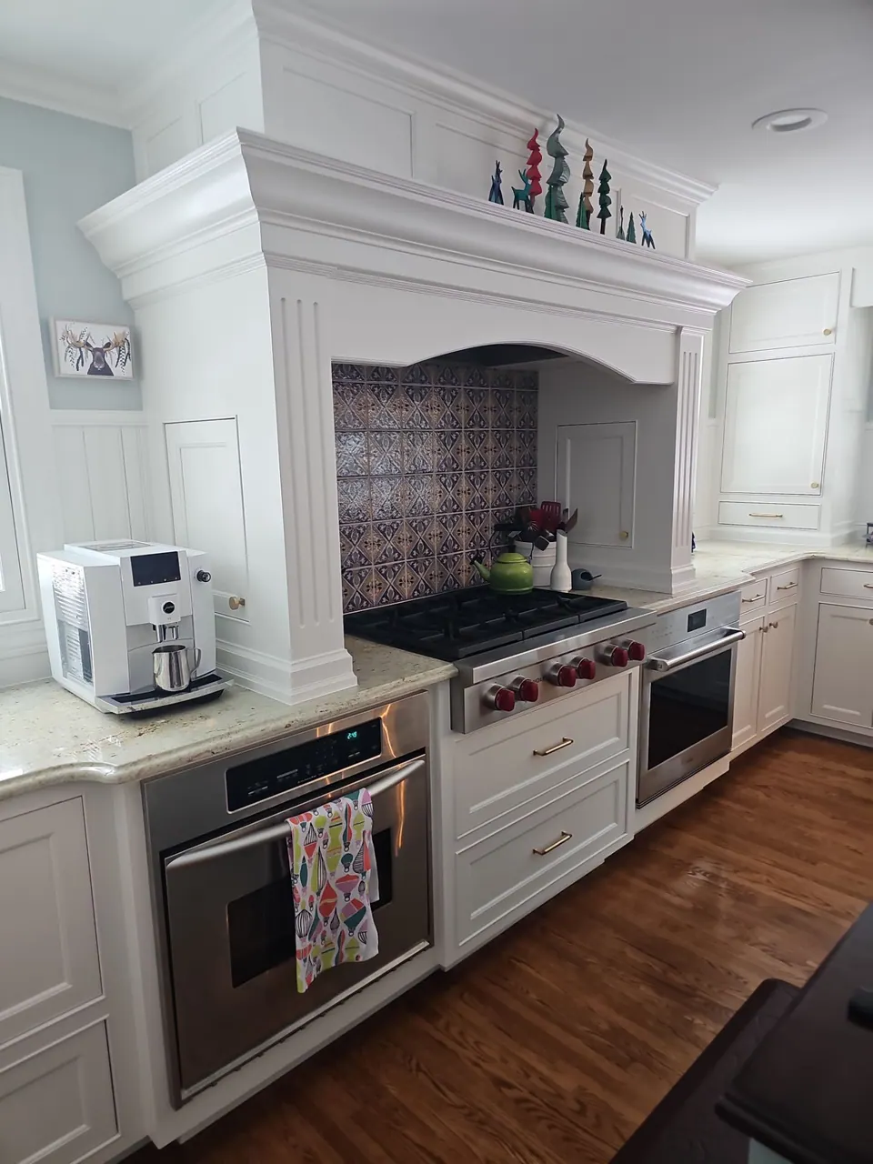 White kitchen cabinets with a painted range hood