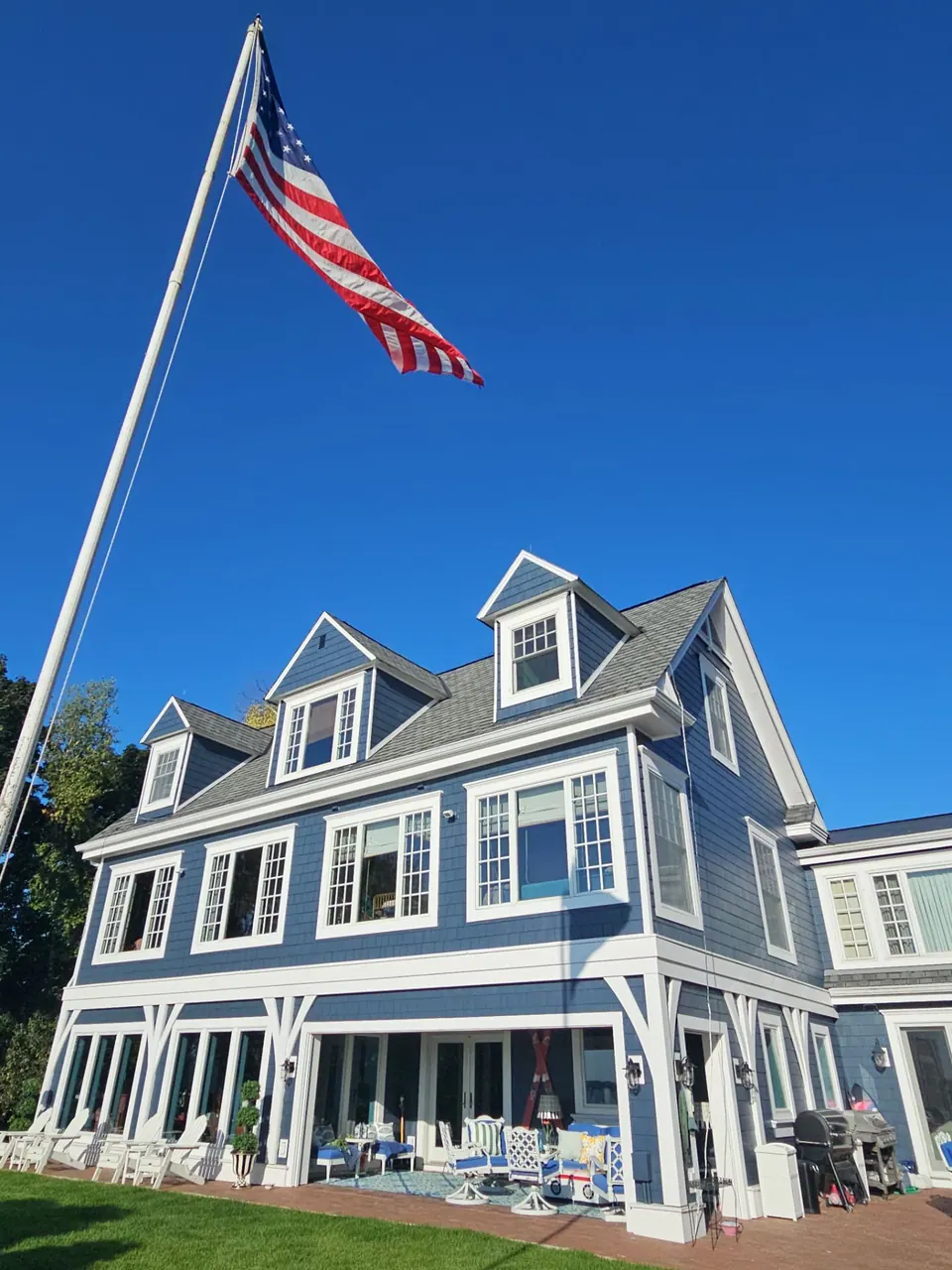 Navy shake siding and white trim on a two-story home painted by Brushtek