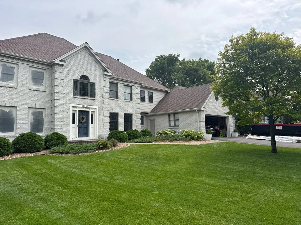 Tan two-story home with painted stucco and trim